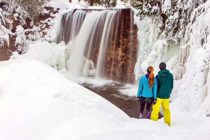 夫妇享受瀑布附近的威斯勒在冬季