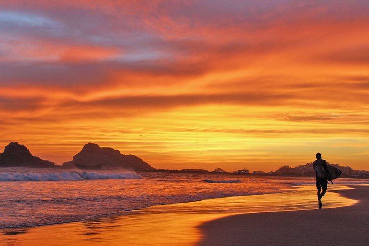 在马萨特兰冲浪者在日落时分在沙滩上