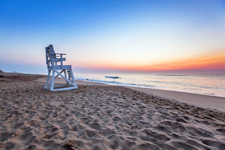 日出时，海岸警卫队海滩上的救生员椅子