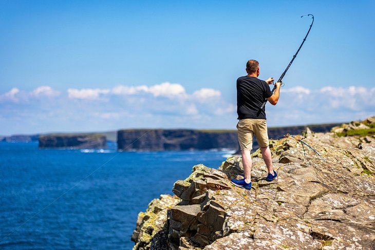 在爱尔兰克莱尔郡Loop Head灯塔的岩石上钓鱼