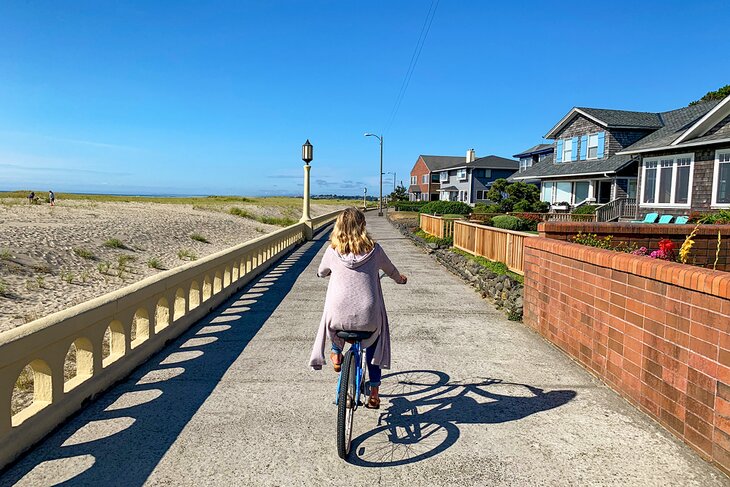 女人骑自行车沿着海滨散步
